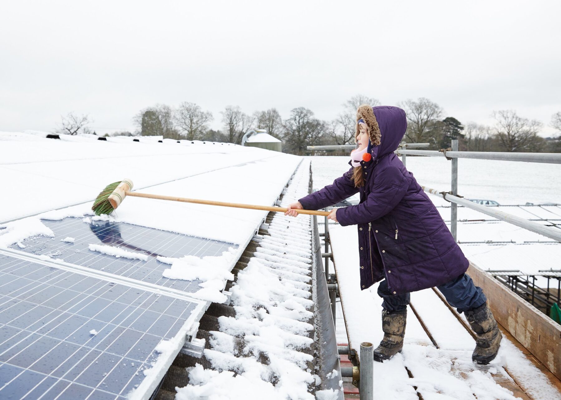 A girl brushes a solar panel at Grange Farm, Balcombe, United Kingdom (Photo by 1010UK (CC))