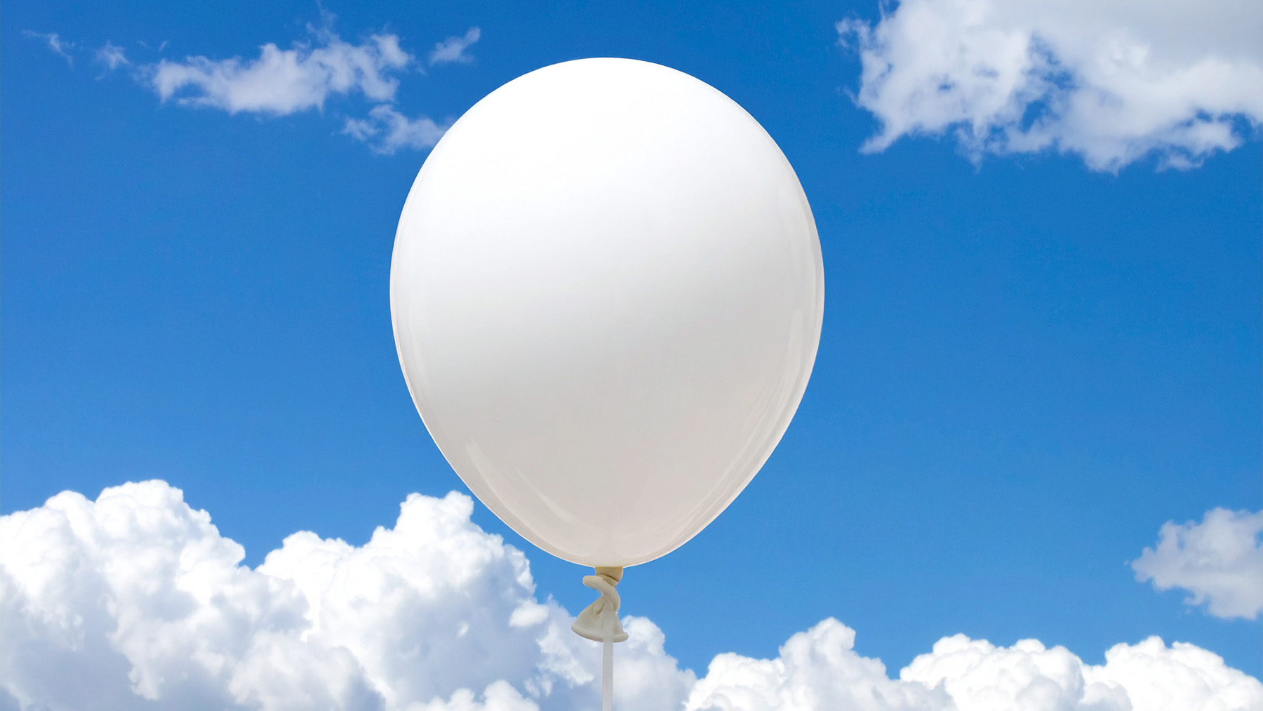 A white balloon against a blue sky (Photo AI generated with Adobe Firefly)